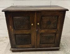 An Indian hardwood cabinet with florally carved panelled doors opening to a single shelf (H77cm
