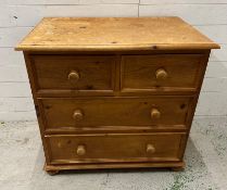 A pine two over two chest of drawers on bun feet (H80cm W85cm D55cm)