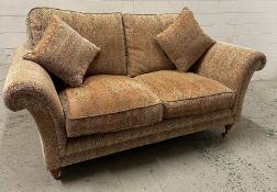 A two seater Parker Knoll sofa upholstered in a floral pattern