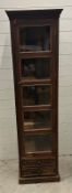 An Indian hardwood glazed display cabinet with five shelves and two drawers under (H176cm W50cm