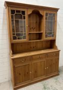 A pine Welsh dresser with astragal glazed doors to top and three drawers and three cupboards
