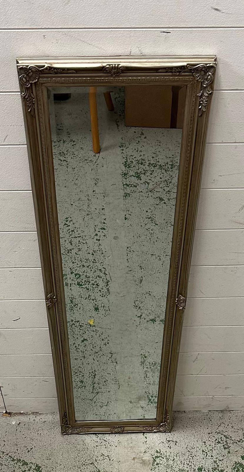 A silver painted bevel edged hall mirror with floral detail 41cm x 132cm