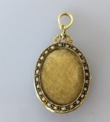 An Edwardian yellow gold oval locket pendant with see pearl decoration, 35 x 25mm