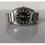 A CWC British military issue stainless steel wristwatch, 1979, with black dial, military arrow, circ