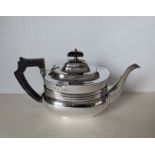 A George V silver teapot with banded girdle, wood handle and knop, hallmarked for William Aitken