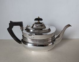 A George V silver teapot with banded girdle, wood handle and knop, hallmarked for William Aitken