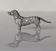 An Art Deco platinum and diamond dachshund brooch with ruby eye decoration, 40mm, unmarked, 9.3g