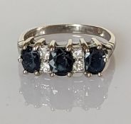 A three-stone graduated sapphire and diamond ring on a white gold setting