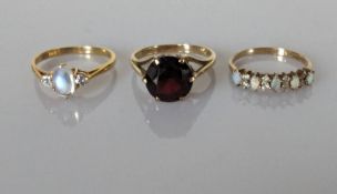 A moonstone and diamond ring on an 18ct yellow gold setting, 2.15g; a faceted garnet dress ring 