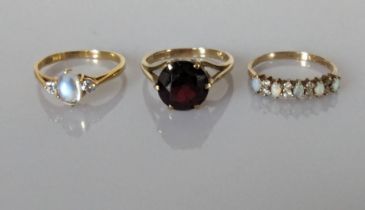 A moonstone and diamond ring on an 18ct yellow gold setting, 2.15g; a faceted garnet dress ring