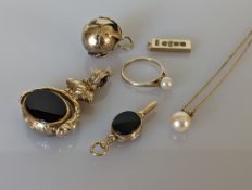 A selection of 9ct gold jewellery to include an ingot pendant, a watch winder