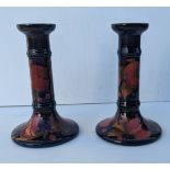 A Moorcroft Pomegranate pair of candlesticks of cylindrical form, decorated in polychrome