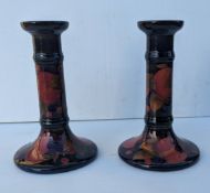 A Moorcroft Pomegranate pair of candlesticks of cylindrical form, decorated in polychrome