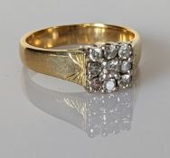 A diamond cluster ring on an 18ct yellow gold panel setting, the nine round-cut diamonds approximate