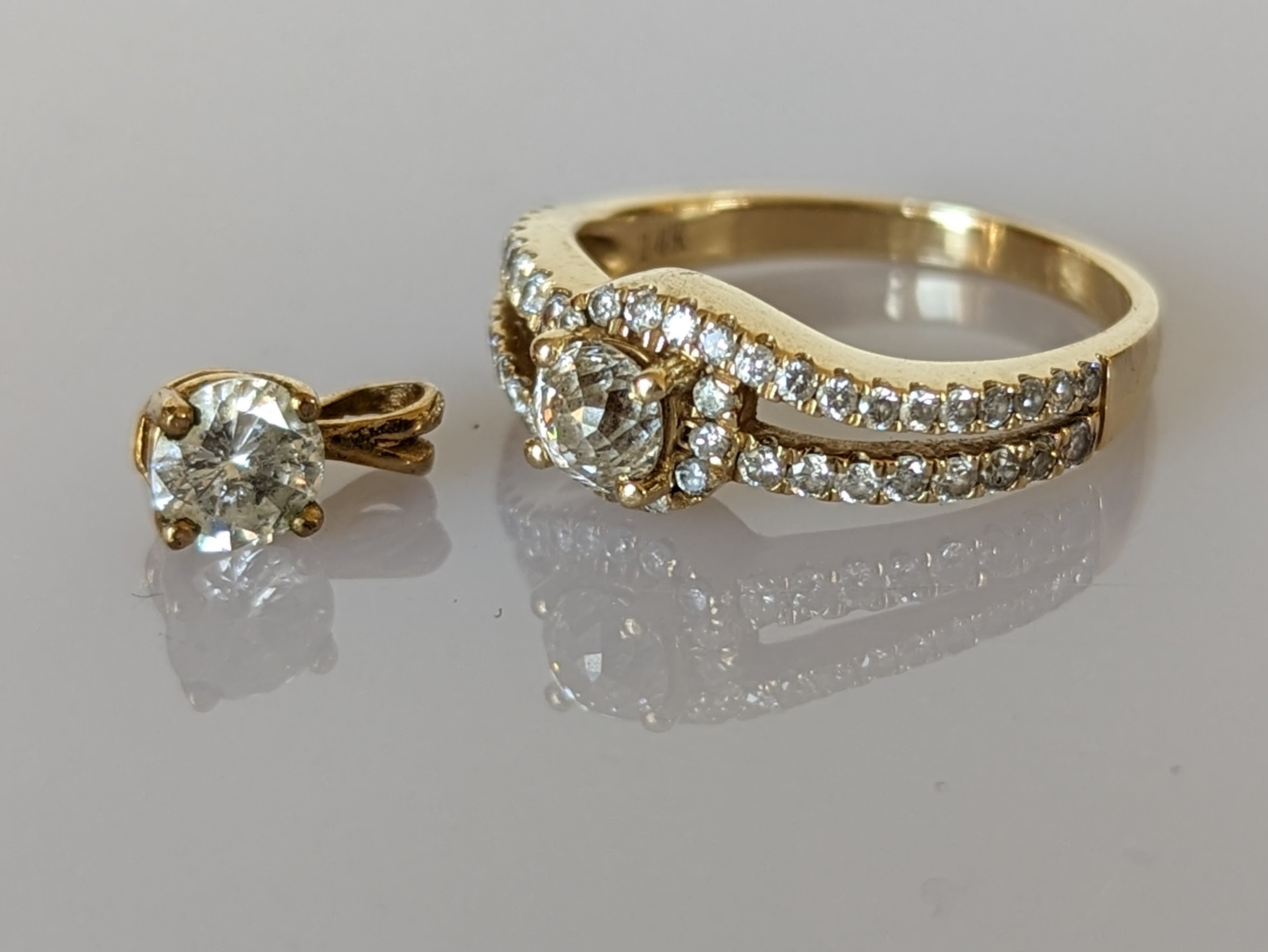 A solitaire diamond ring with split shoulder shank, decorated with diamonds to both sides