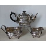 An Edwardian silver tea service with rococo decoration to rims, embossed half-fluted design