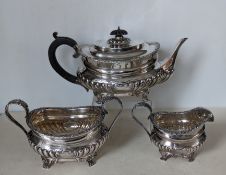 An Edwardian silver tea service with rococo decoration to rims, embossed half-fluted design