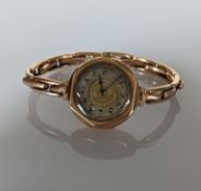 A 1920s ladies manual wristwatch with Arabic numerals, hexagonal rose gold case and elastic strap