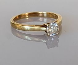 A solitaire diamond ring on a yellow gold claw setting