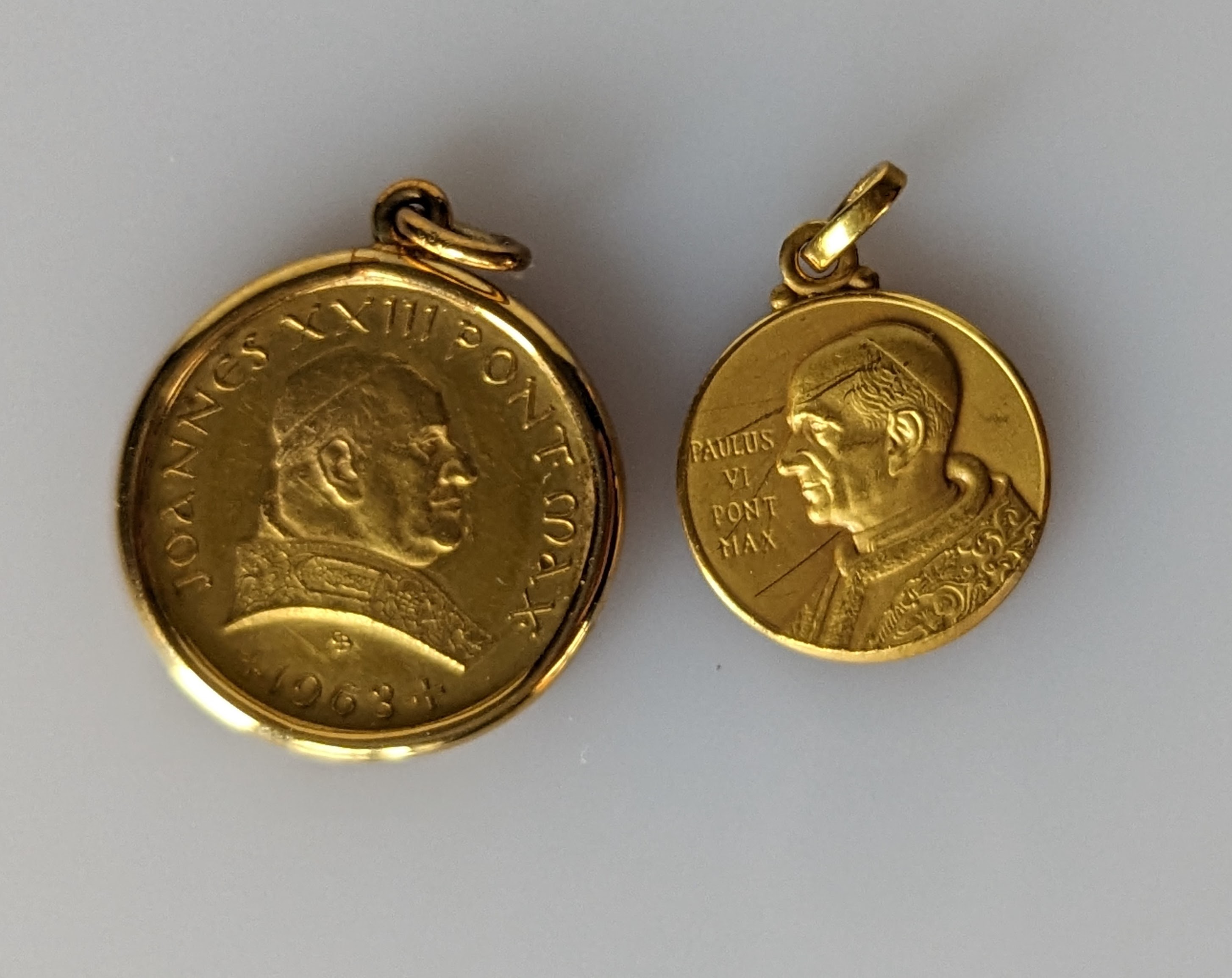 A Pope Paul VI gold pendant, 14mm diameter, stamped 750 and a Pope John XXIII 