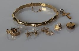 A bamboo effect gold bangle, 65mm, as found; a gold crucifix, four pair of earrings and a locket