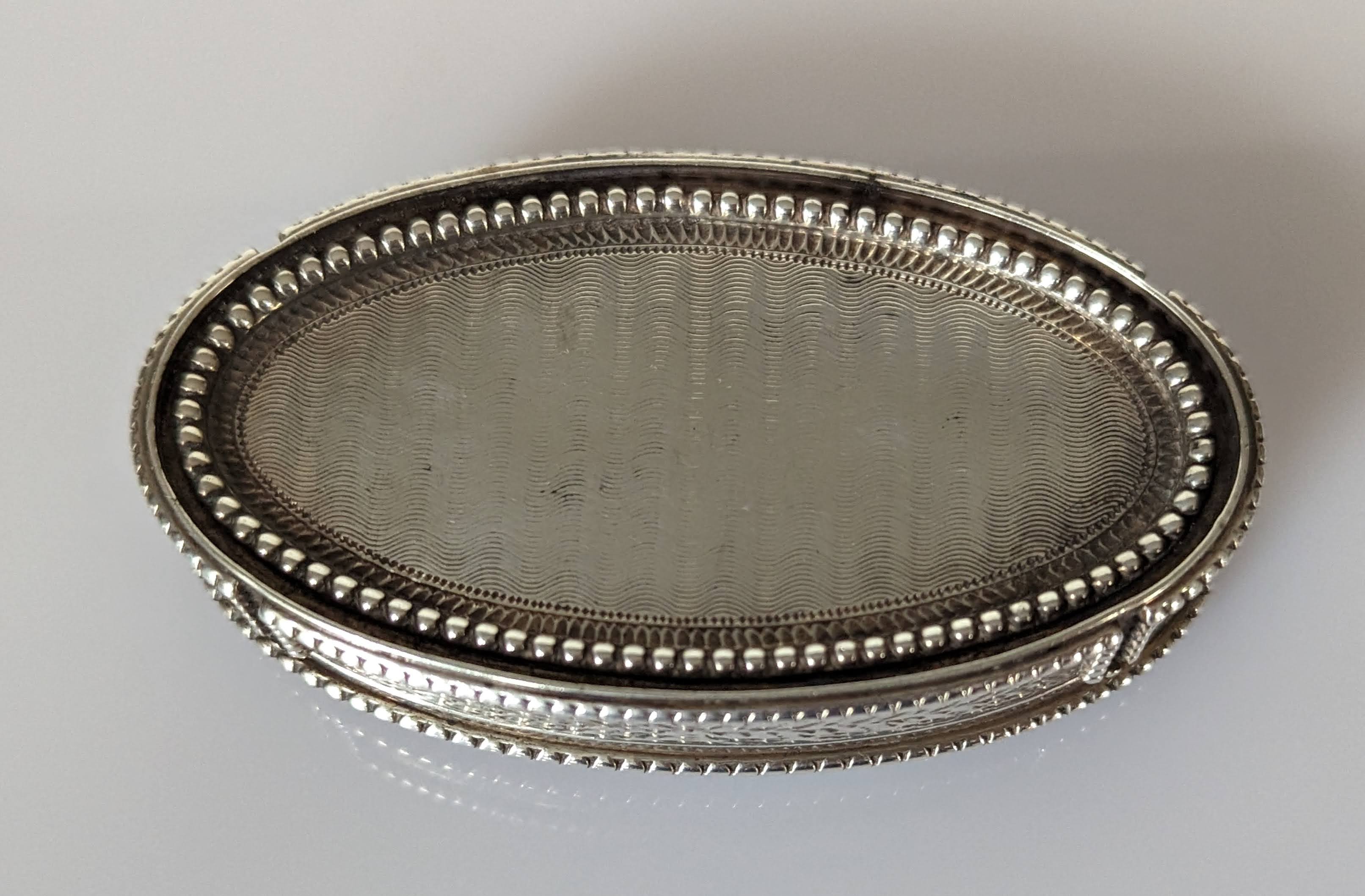 A George III oval silver snuff box with hinged lid, beaded border, engine turned, etched decoration - Image 4 of 4