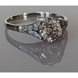 An Art Deco solitaire diamond ring with diamond decoration to the split shank shoulders