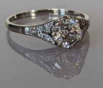 An Art Deco solitaire diamond ring with diamond decoration to the split shank shoulders
