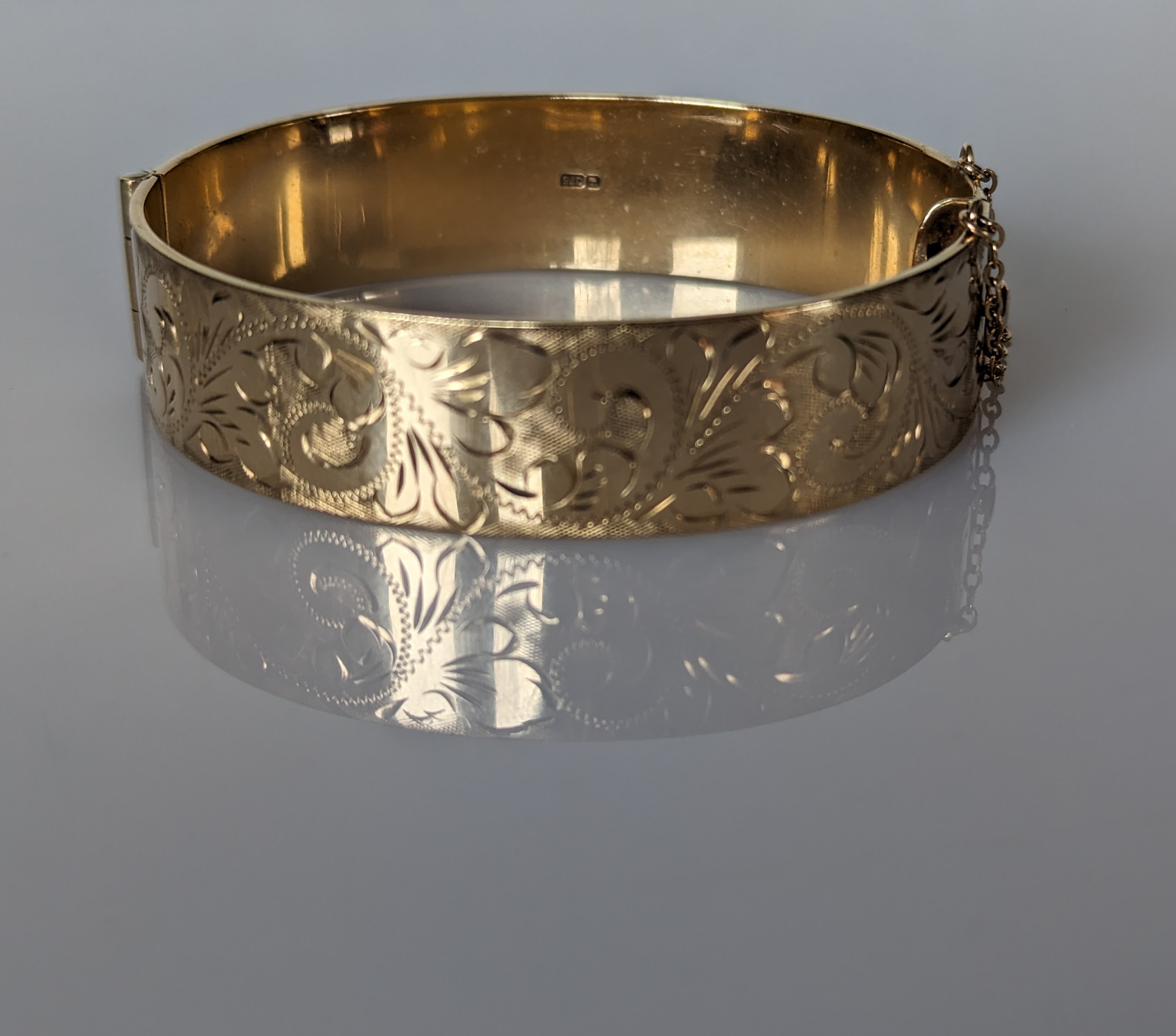 An etched 9ct gold bangle, 60mm, hallmarked for R P H Jewellery Co Ltd, Birmingham, 44g