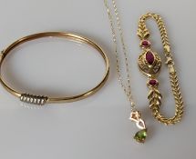 A yellow gold bangle with applied decoration, 60mm and a peridot pendant chain, both 9ct, 8.15g 