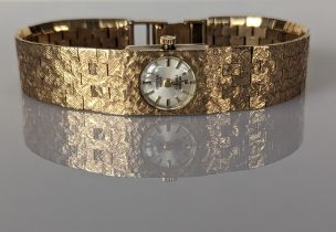 A vintage Oriosa ladies watch with champagne dial, baton markers on a 9ct yellow gold textured brick