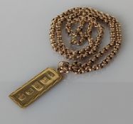 A 9ct yellow gold ingot pendant on a rose gold belcher chain, 58 cm, hallmarked, 32.4g