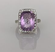 An amethyst dress ring on a white gold claw setting setting surrounded by diamonds