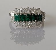 An emerald and diamond cluster ring on a white gold setting