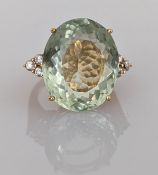 An oval-cut prasiolite and white sapphire dress ring on a yellow gold claw setting