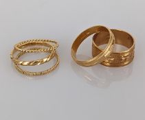 Five gold bands, some with etched decoration, all stamped 750, mixed sizes, 10.4g