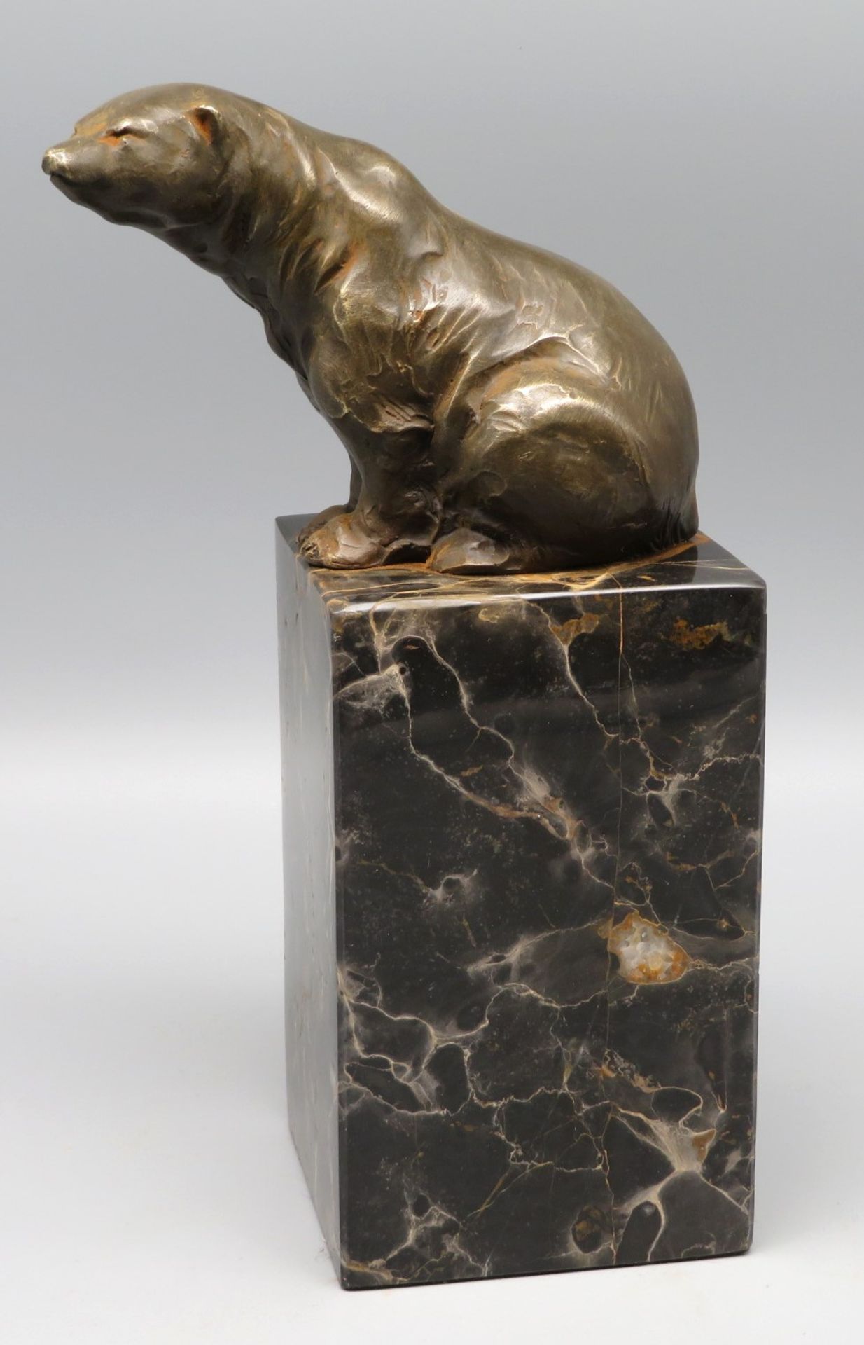 Sitzender Bär, Bronze patiniert, schwarz marmorierter Marmorsockel, 21,5 x 11,5 x 7,8 cm.