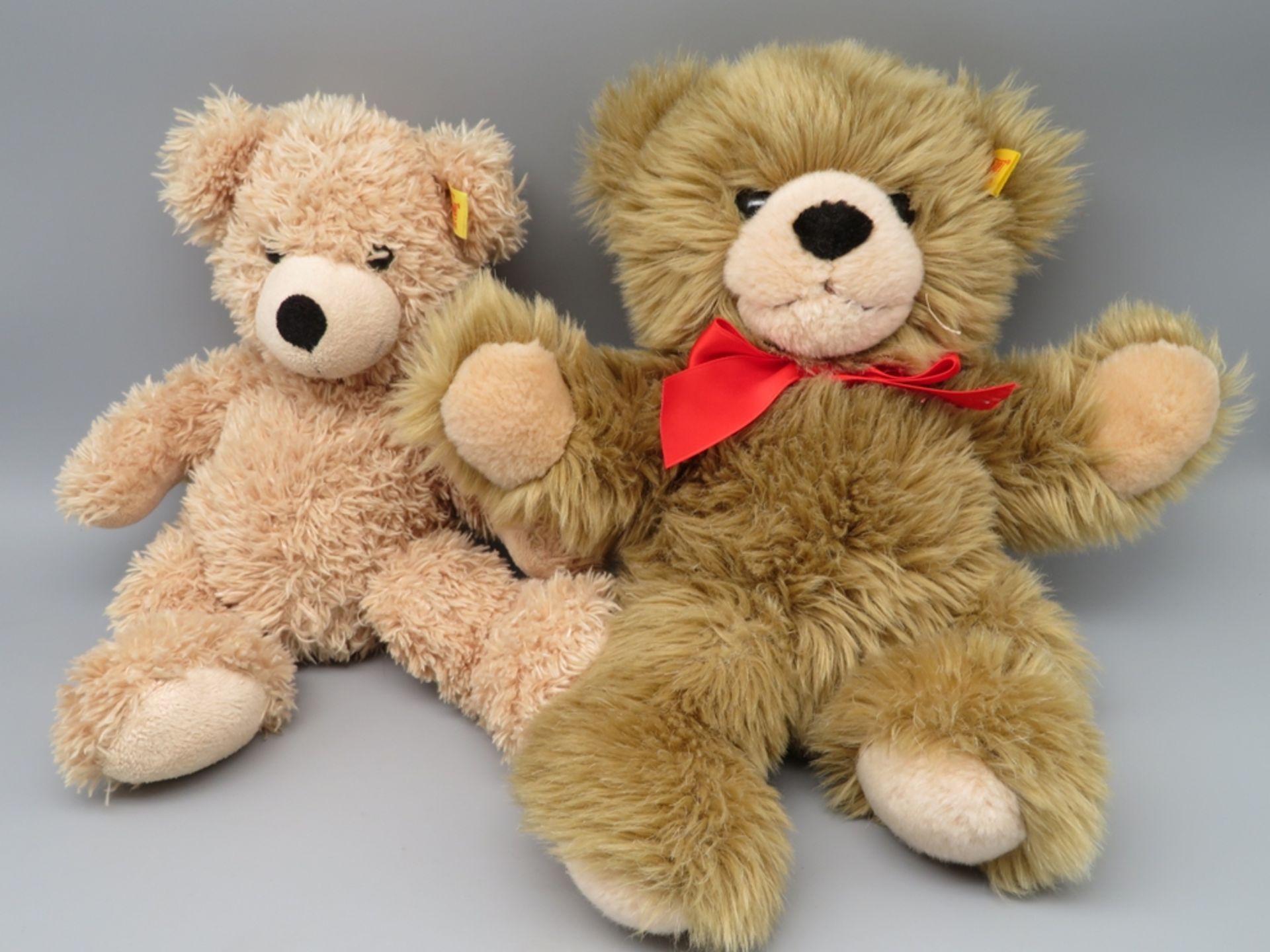 2 diverse Teddybären, Steiff, Kopf und Fahne im Ohr, l 29/30 cm.