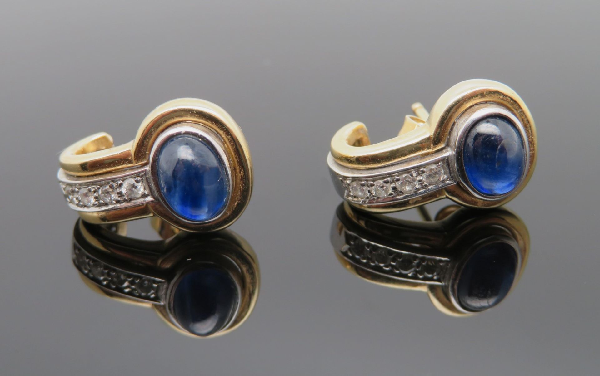 Paar Ohrstecker, 2 Saphir-Cabochons, zus.ca. 1 ct, 8 Diamanten, zus.ca. 0,16 ct, Gelb- und Weißgold