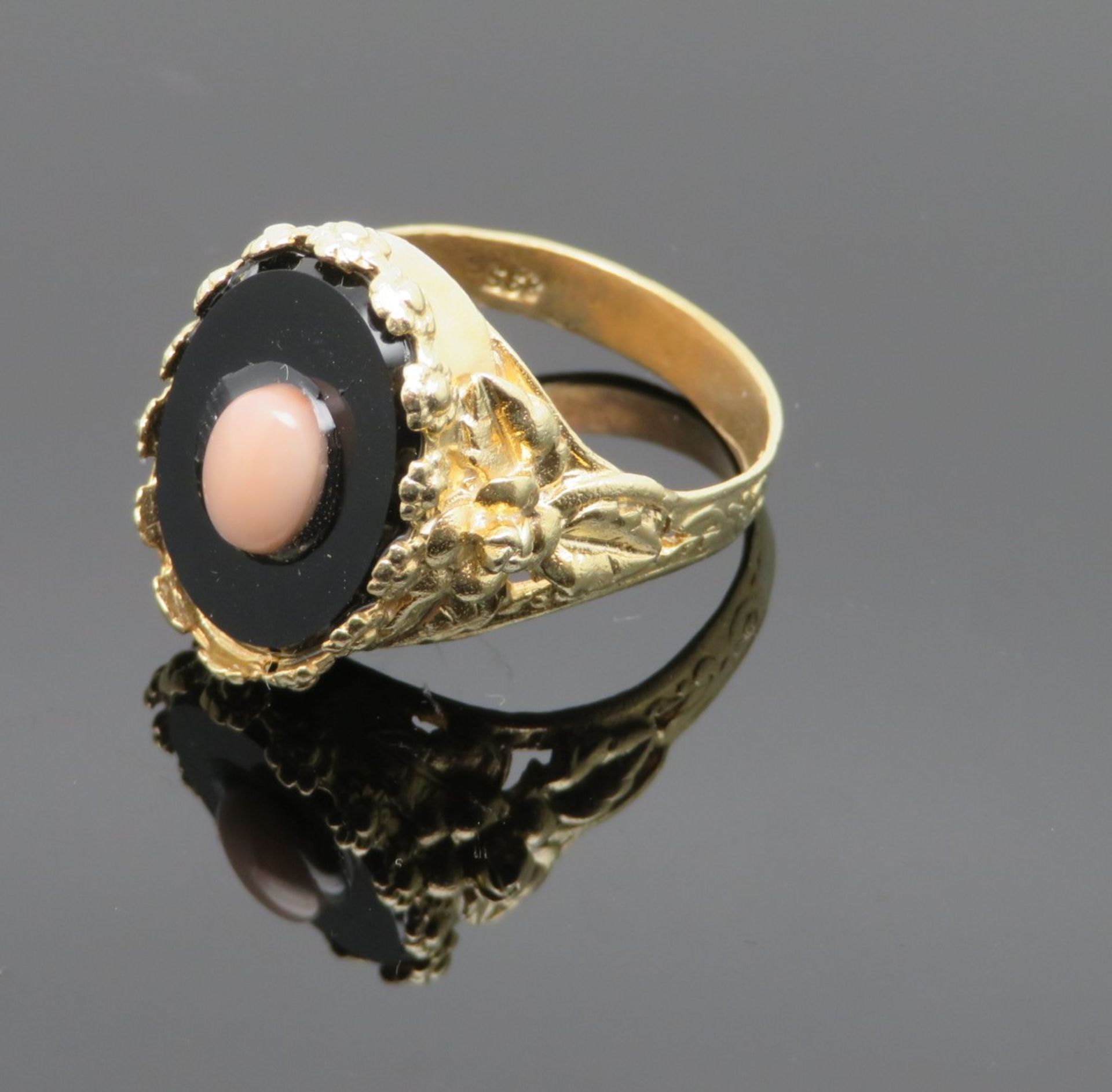 Onyx-Korallen-Ring, Ringkopf besetzt mit ovaler schwarzer Onyx-Platte (ca. 7 ct) in floraler Umrahm