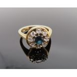 Entourage-Ring, facettierter Saphir, ca. 0,25 ct, entouriert von 8 Brillanten, zus.ca. 0,4 ct, Ring