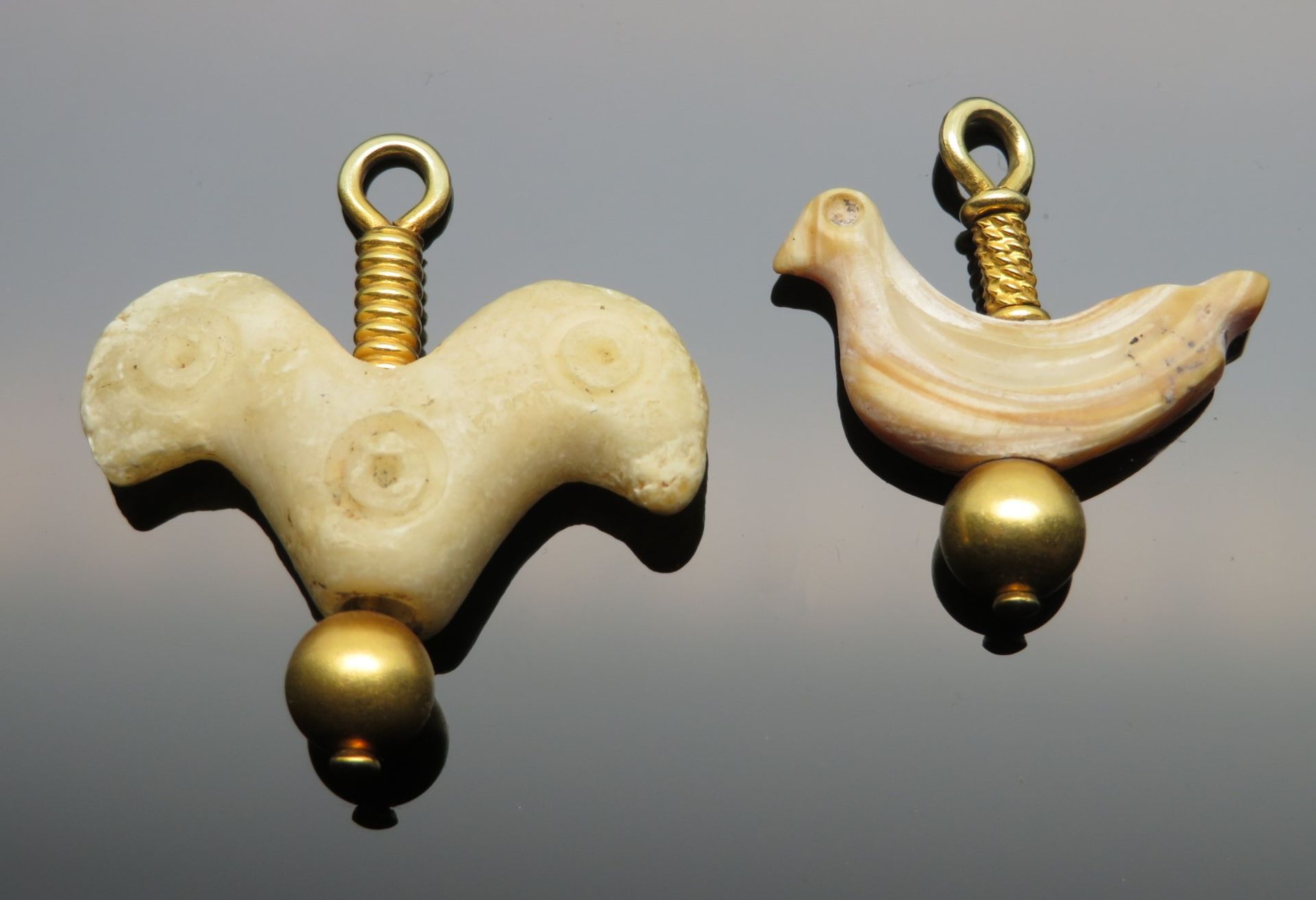 2 Anhänger in Gestalt von Vögeln, Stein geschnitzt, Fassungen Gelbgold 585/000, geprüft, 2,2/2,9 x 