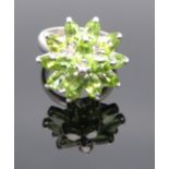 Peridot-Cocktailring, erhaben gearbeitete Blütenform, diese besetzt mit 15 facettiertem Peridoten (