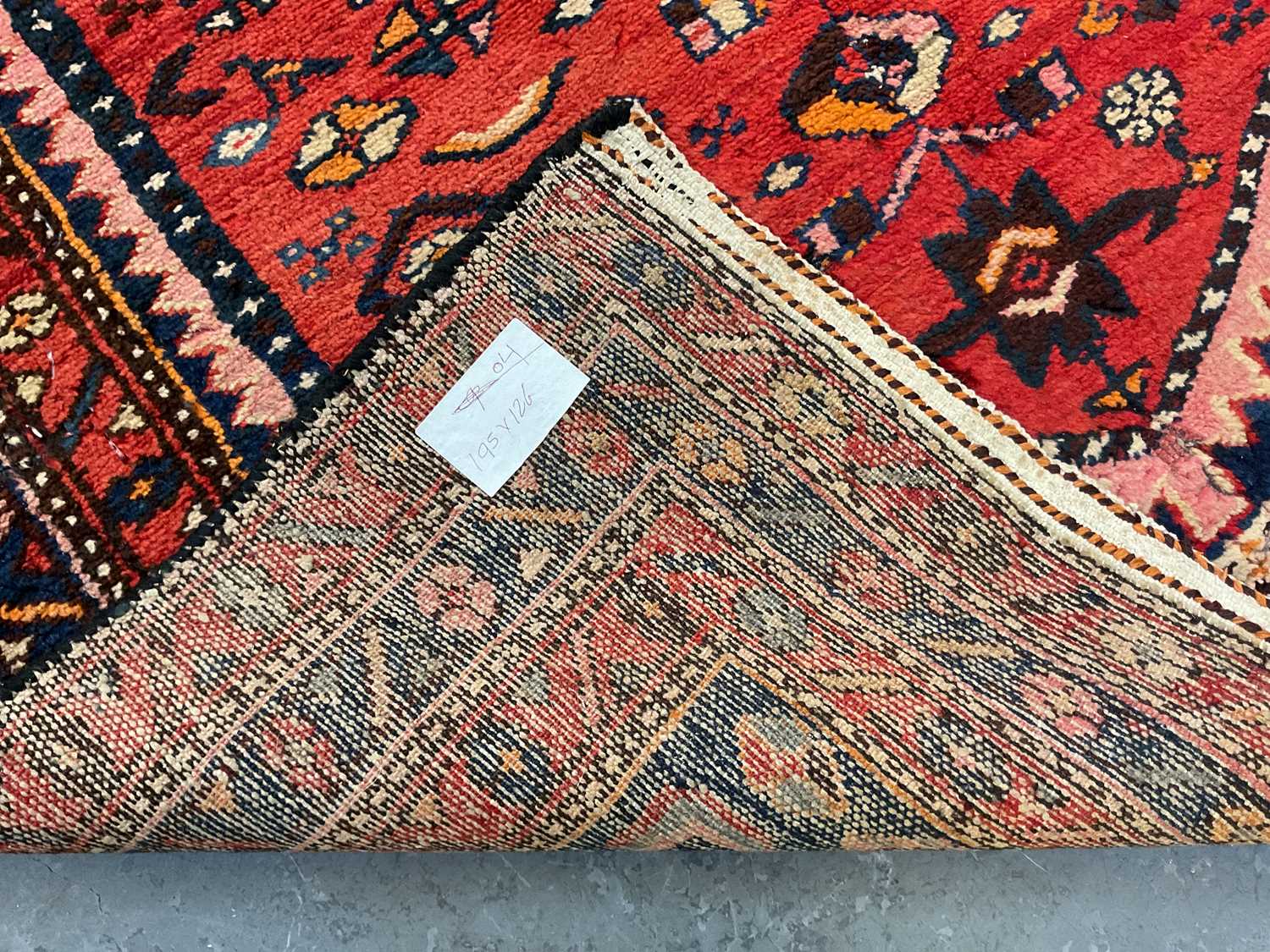 An antique Persian red ground carpet, with central triangular medallion surrounded by blue and red - Image 4 of 4