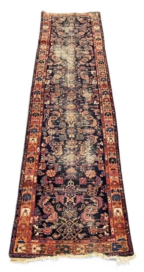 An antique Persian blue and red ground runner, the central blue ground panel decorated with foliage,