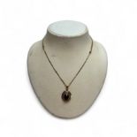 Gold pendant with faceted garnet on necklace