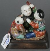 Kindergruppe. Japan Meiji-Periode (1868-1912). Kutani-Porzellan, bunt bemalt, auf Holzsockel, H=10,6