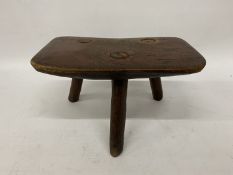A 325 YEAR OLD MILKING STOOL MARKED TO THE BASE, '1700 STANLEY MOOR'