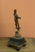 A patinated and gilt-bronze figure of a nude young man standing on a dolphin Italy, Venice, 16th Cen