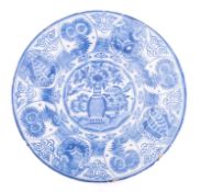 A Dutch blue and white delftware charger painted in the Chinese Kraak style with a central vase of